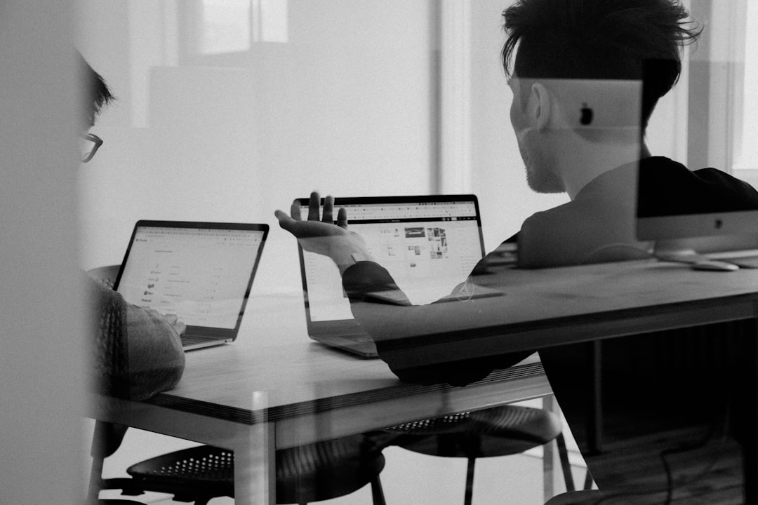 Team creativo che lavora con strumenti AI su schermi e lavagna