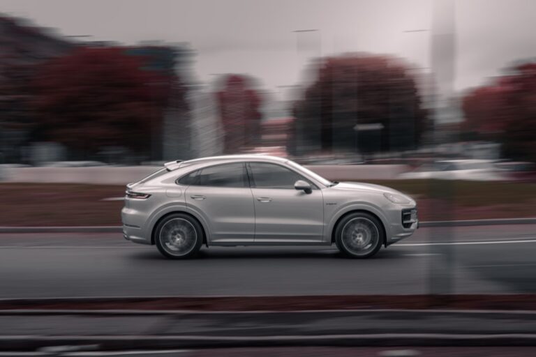 Porsche Cayenne Turbo Coupe elettrica blu in movimento su strada