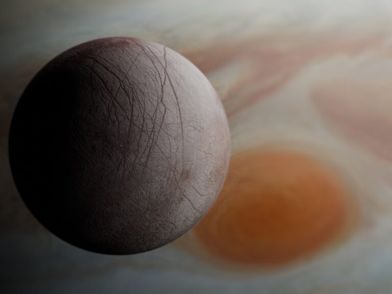 Primo piano della superficie ghiacciata di Europa, una delle lune di Giove, con crepe e striature sulla crosta