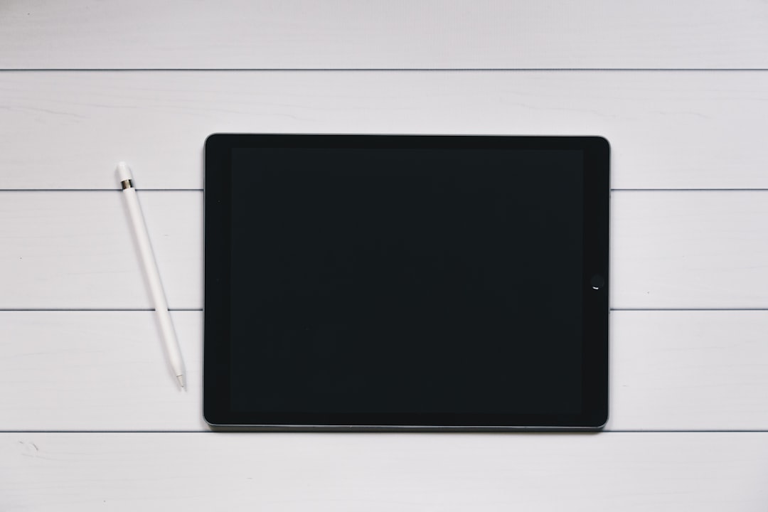 Persona che scrive su un taccuino digitale e-ink in un ambiente minimalista, rappresenta la tecnologia della disconnessione e semplicità