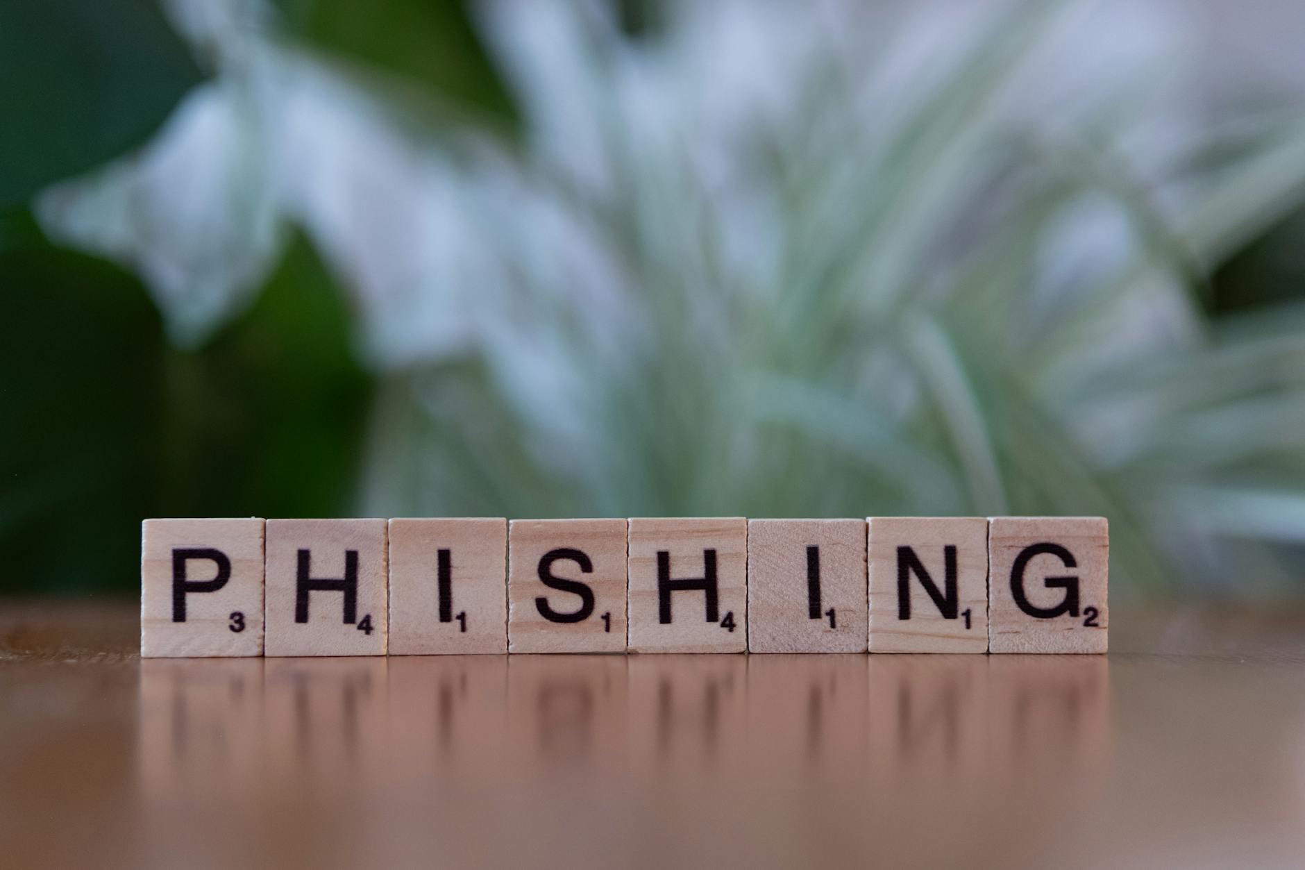 Attacco phishing SMS di Scattered Spider con telefono e schermo digitale