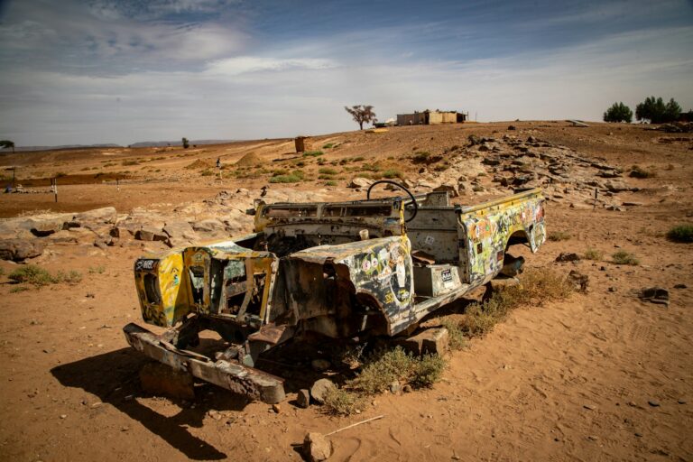 Auto sgangherata in un deserto post-apocalittico, atmosfera Mad Max