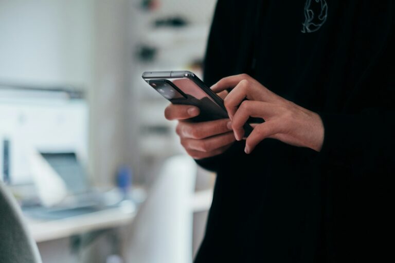 Persona che usa uno smartphone, connessione tra tecnologia digitale e attenzione umana