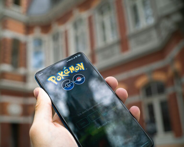 Giocatore di Pokemon Go con smartphone durante una passeggiata, mappa del gioco sullo schermo