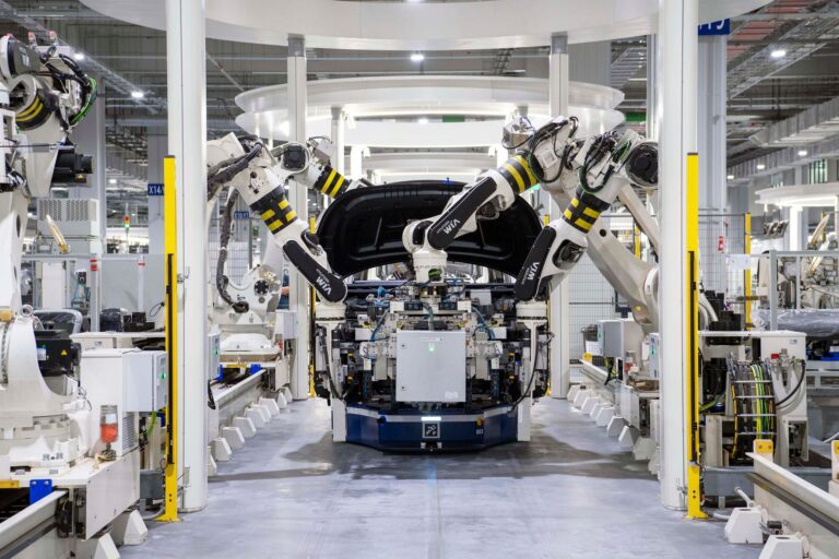 Stabilimento Volkswagen con catena di montaggio e auto in produzione