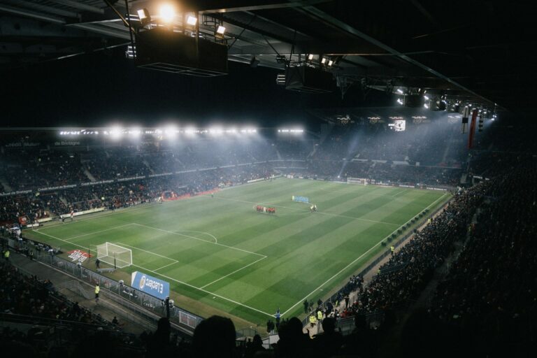 Stadio di calcio di notte, sullo sfondo il bilancio 2025/2026 della Juventus